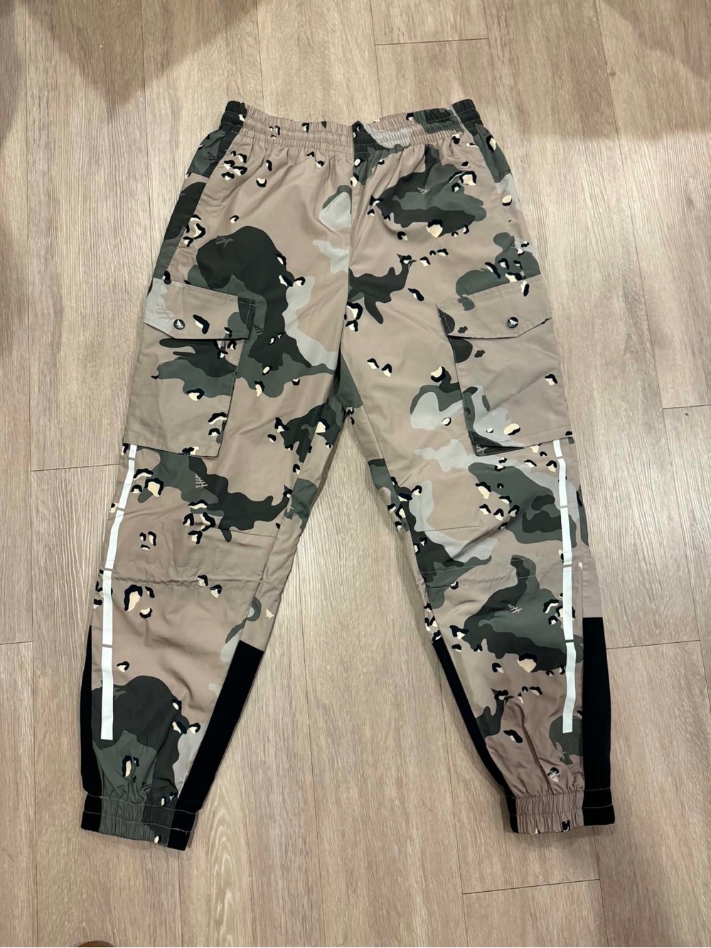 Paper Planes multi-pocket cargo pants featuring an all-over camouflage print